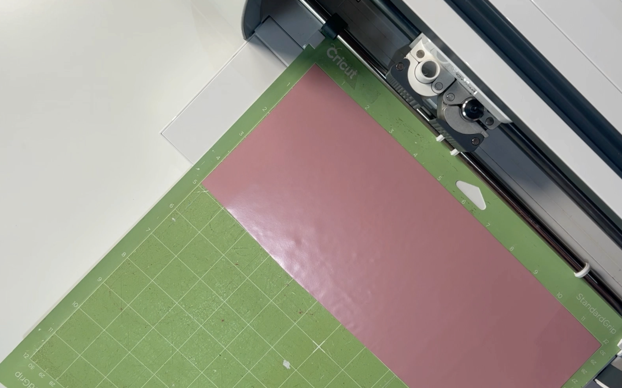 The rose gold heat transfer vintl on the mat in the cricut machine ready to be cut. 