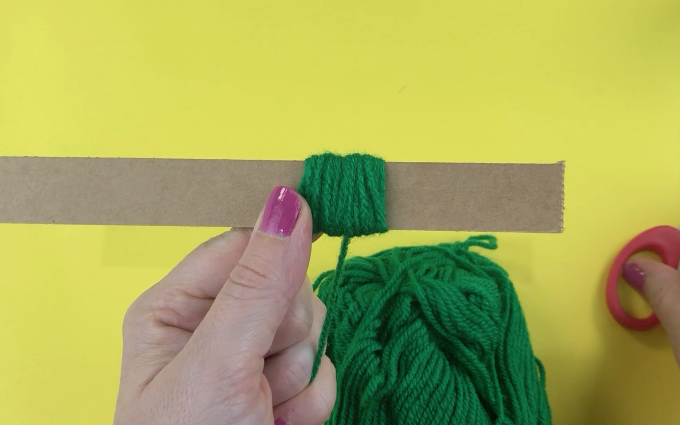Wrapping the green wool around a piece of card board 2cm wide. 