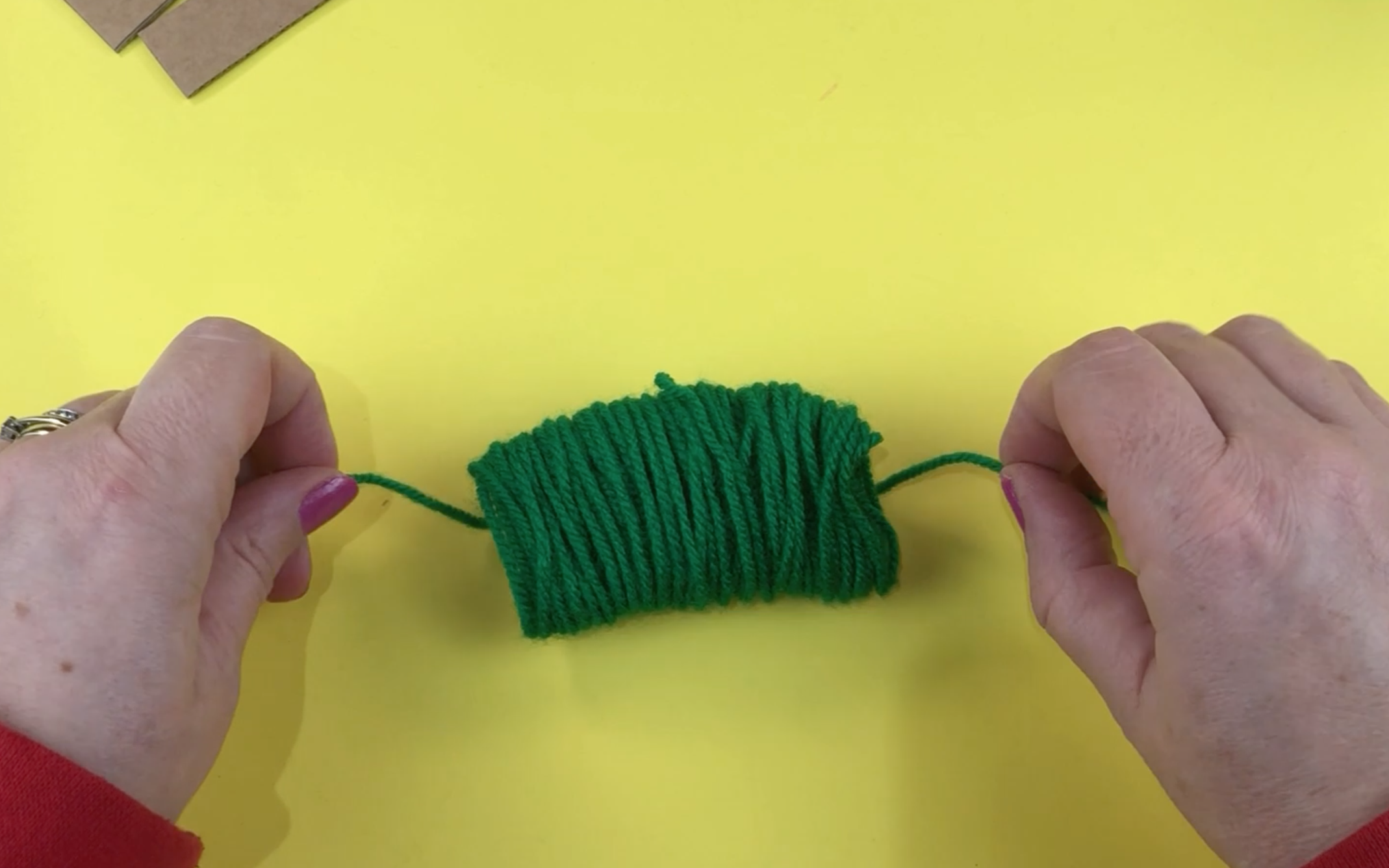 A long piece of wool with the wrapped wool through the middle ready to be tied. 