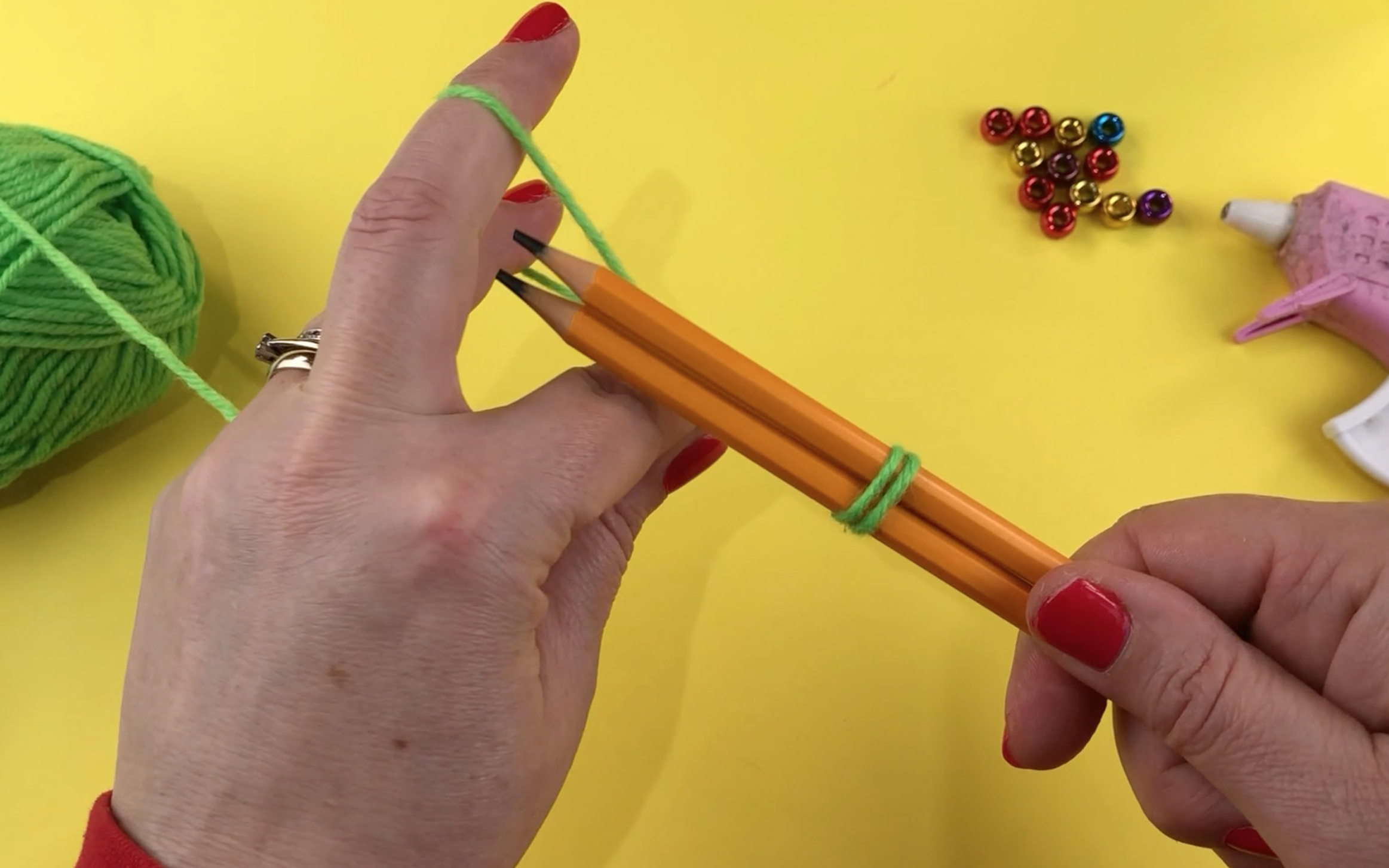Wrapping green wool around 2 pencils to make a loop