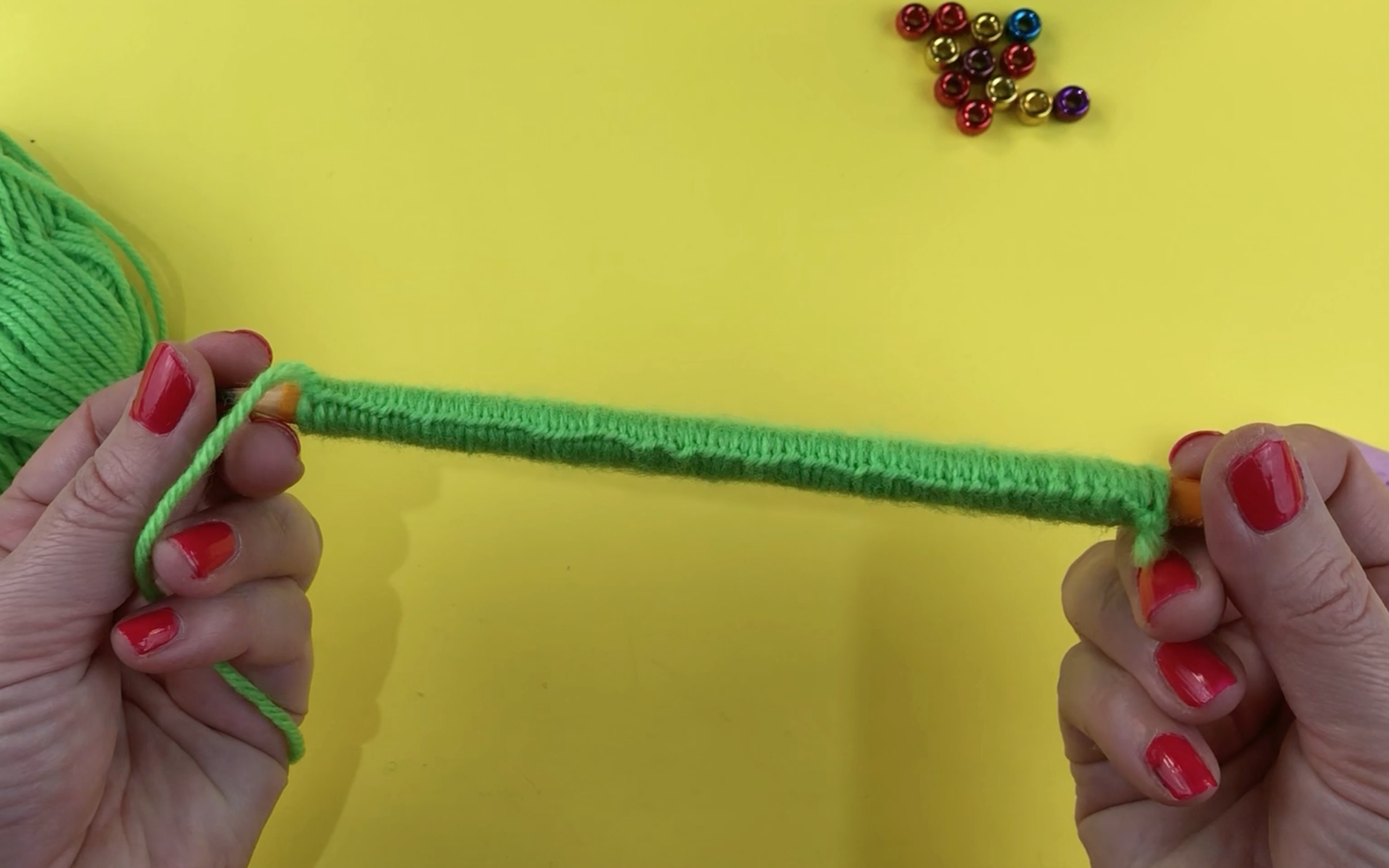 Showing the pencil fully covered in green looped wool.