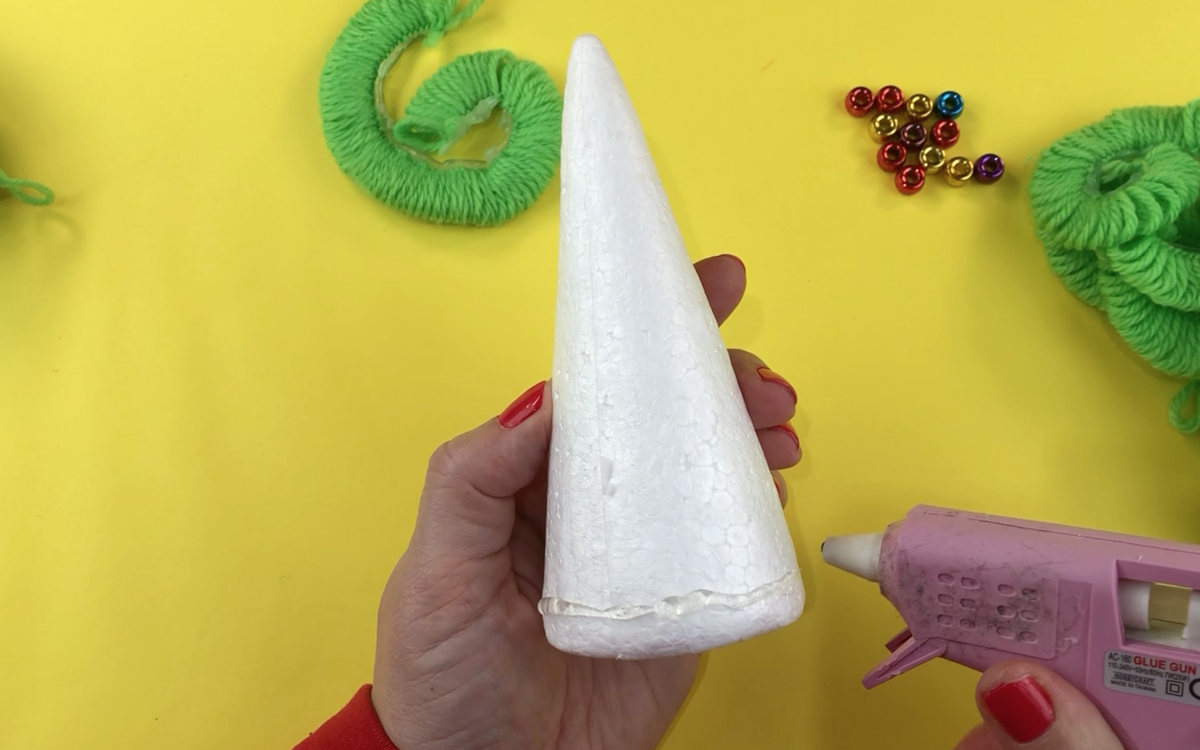 Adding hot glue to the bottom of the polystyrene cone