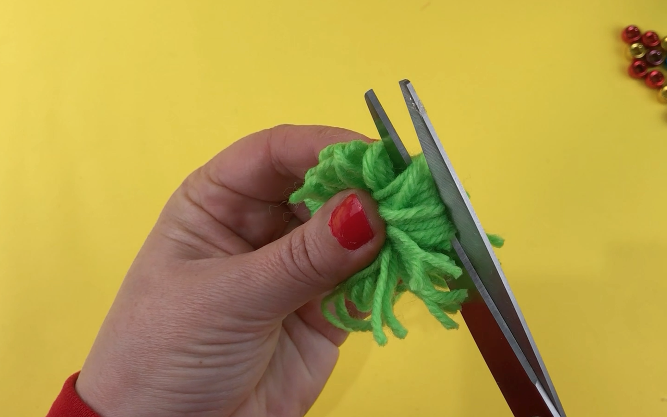 Cutting through the hoops of the pompom