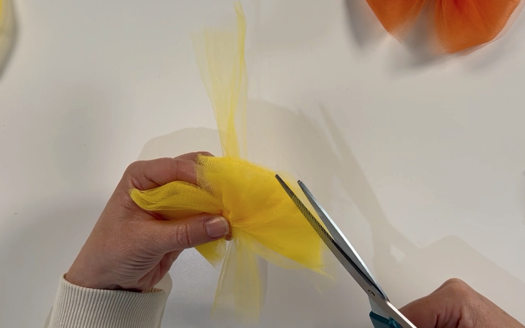 Cutting through the edges of a tulle bow.