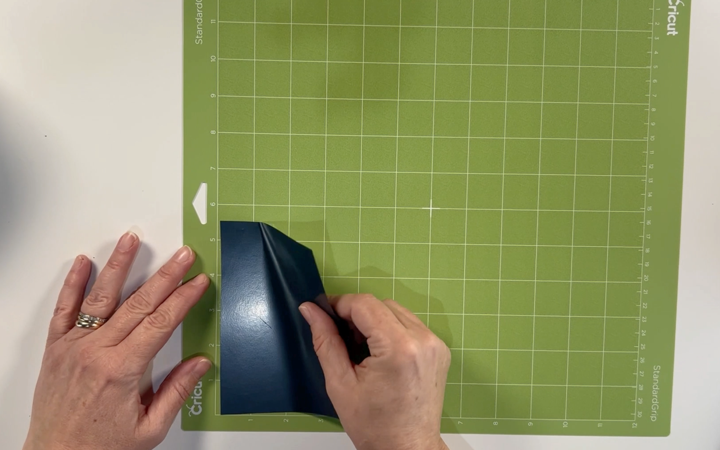 Placing the heat transfer vinyl in the top corner of the standard grip cutting mat