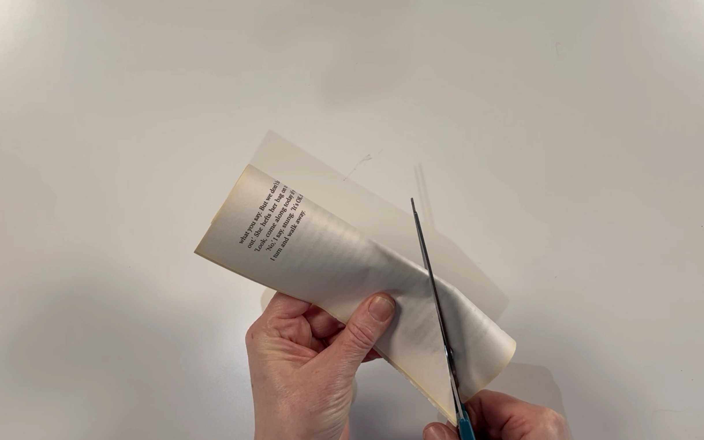 The book pages folded in half long ways and being cut in a diagonal line to form the flags