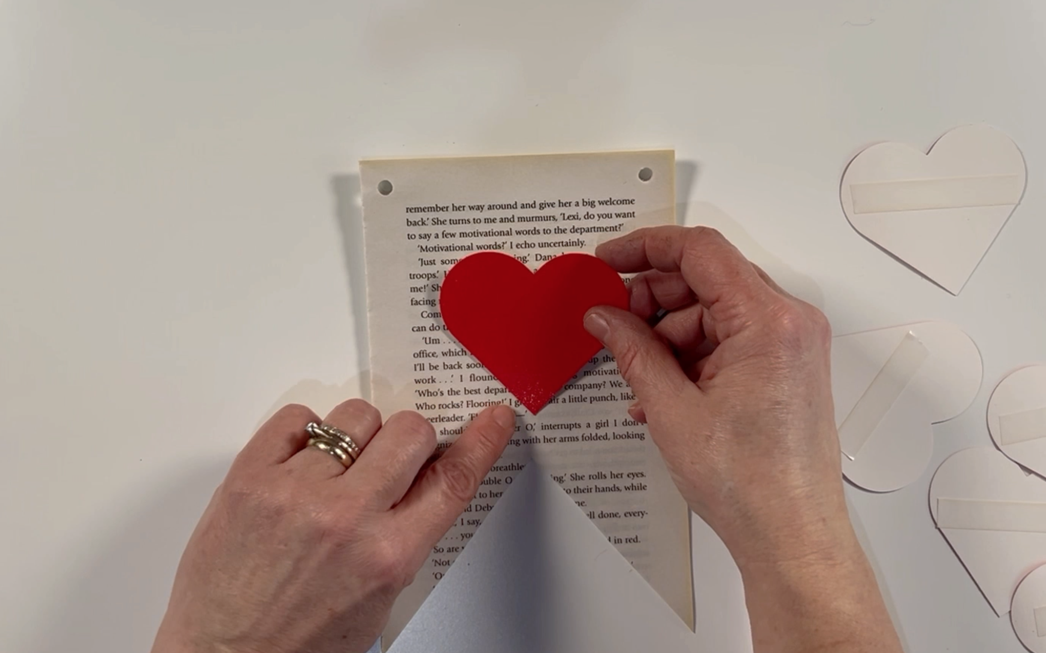 Positioning the hearts in place on the book pages.