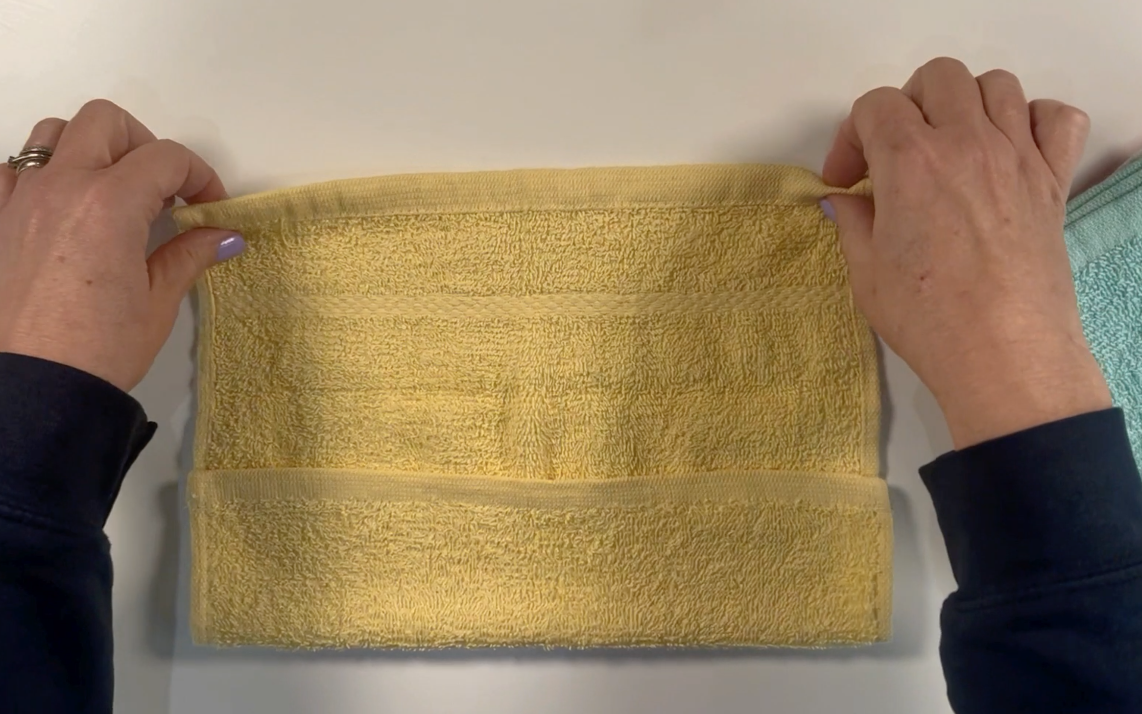 Folding the washcloth over at the top and the bottom