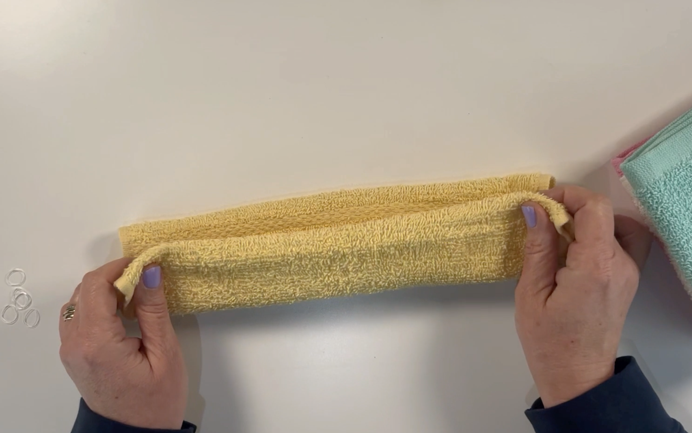 Folding the washcloth in half again longways.