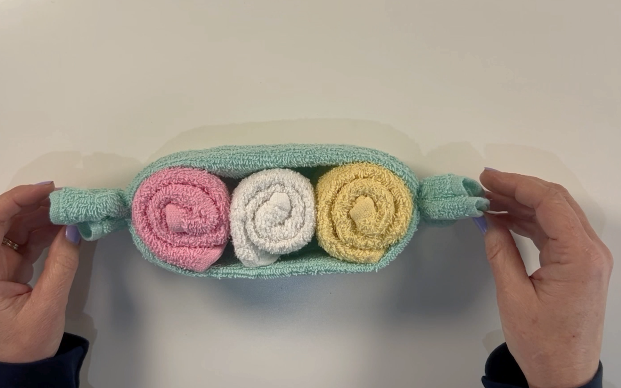 A completed peas in a pod made using a pink, yellow, white and green washcloth