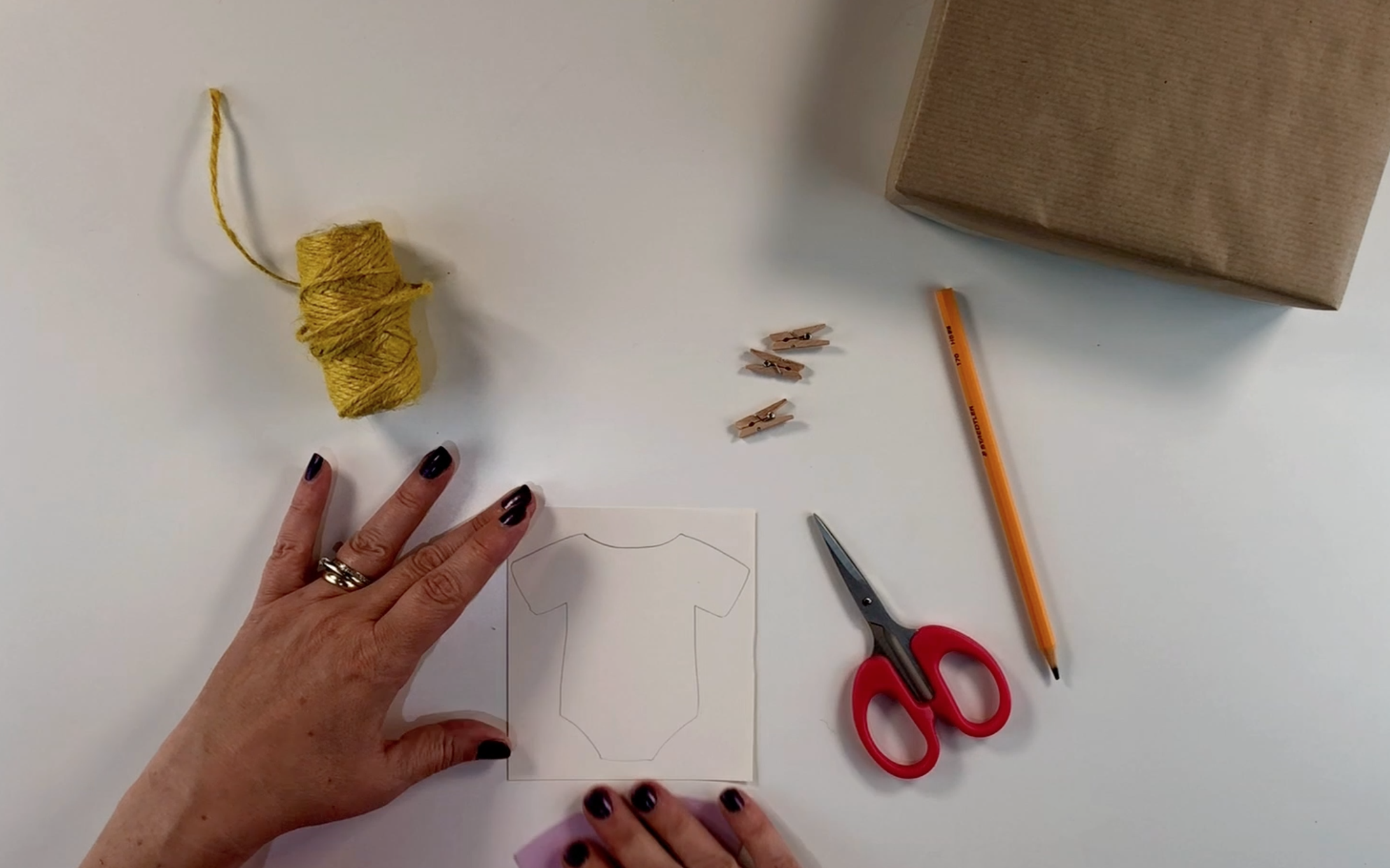 Drawing a baby vest on the card to make a tag. 