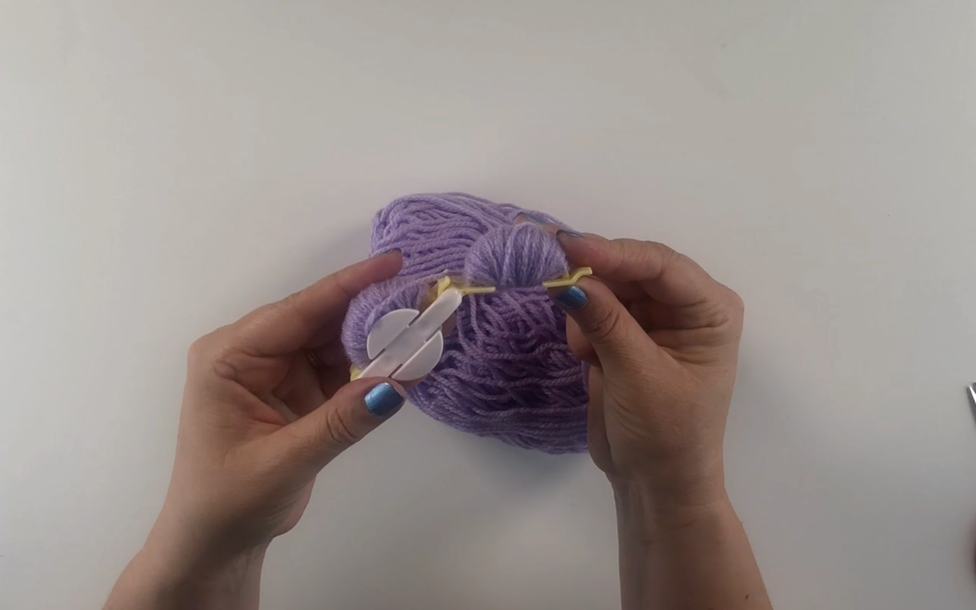 Purple wool wrapped around the pompom maker 