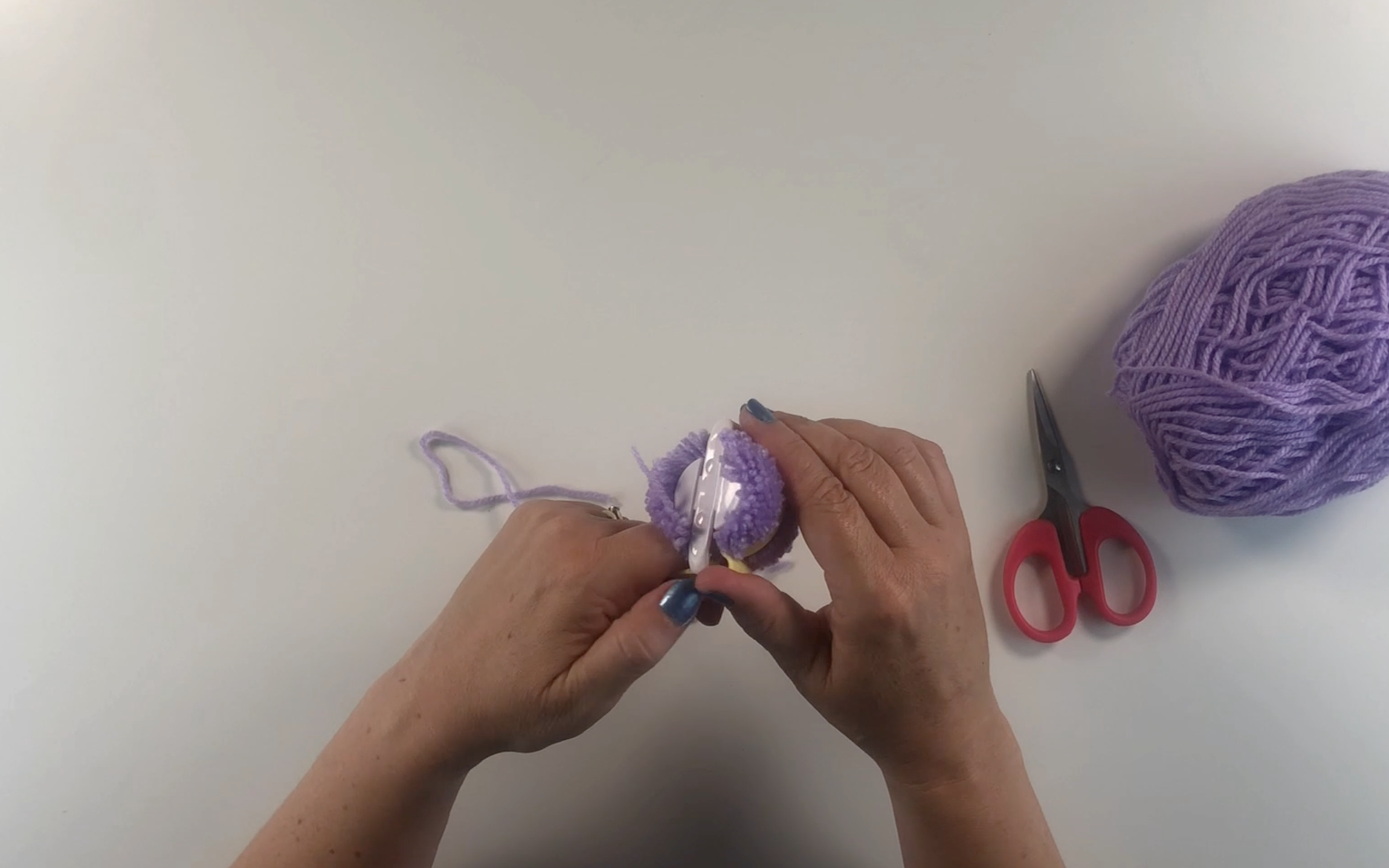 Removing the pompom from the pompom maker.