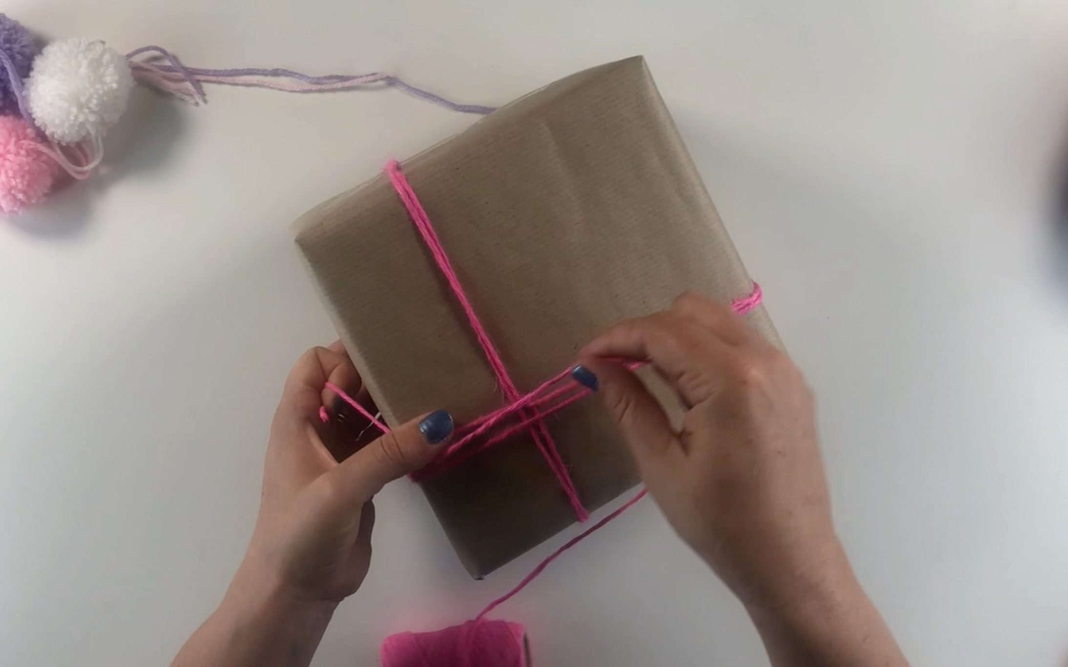 Wrapping the pink twine around the present. 