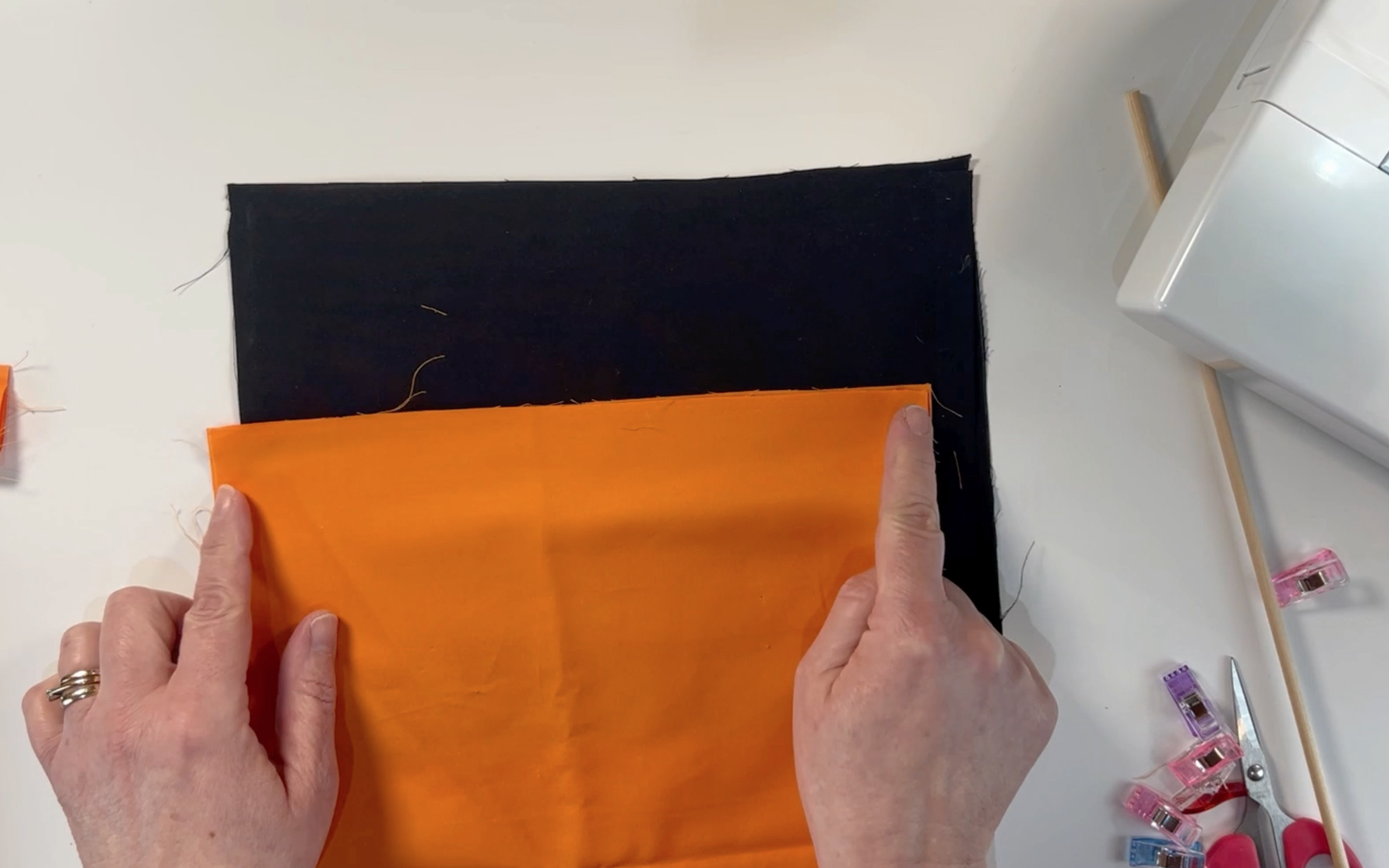 2 pieces of orange and black material cut to be 20cm by 26cm. 