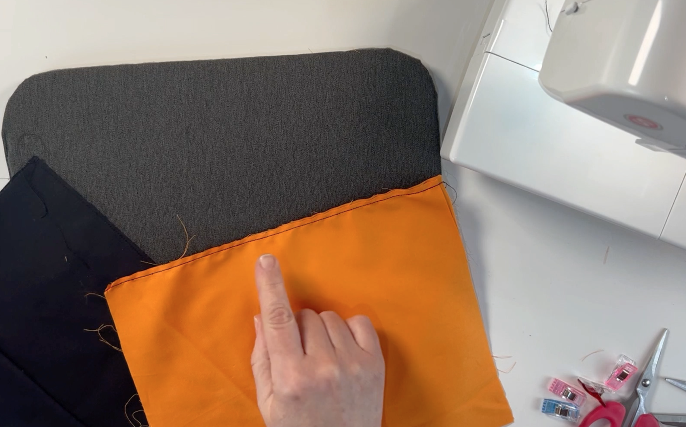 the orange material sewn all the way along the longest edge
