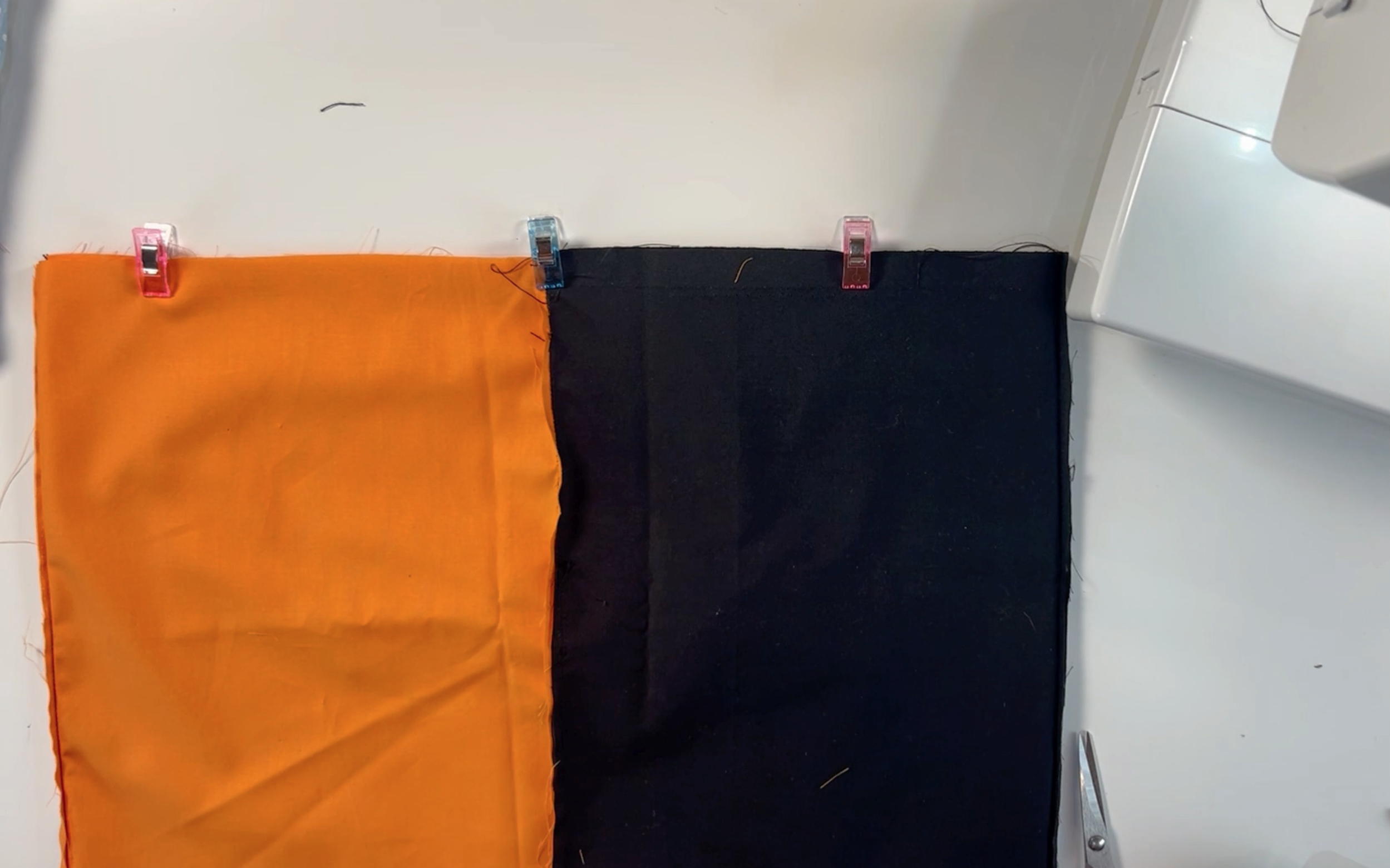placing the black material pieces together and the orange material pieces together and clipping them together