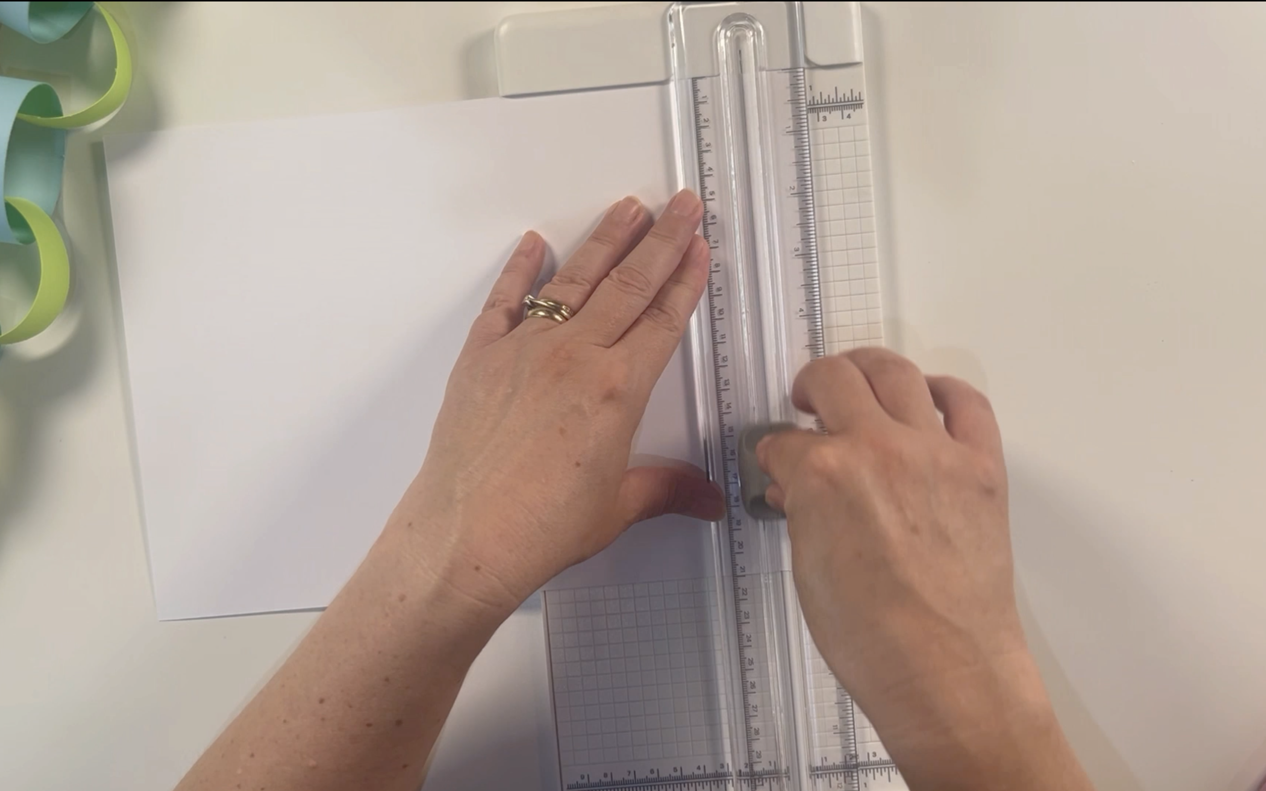 Cutting the white card along the shortest edge using the cricut paper trimmer.