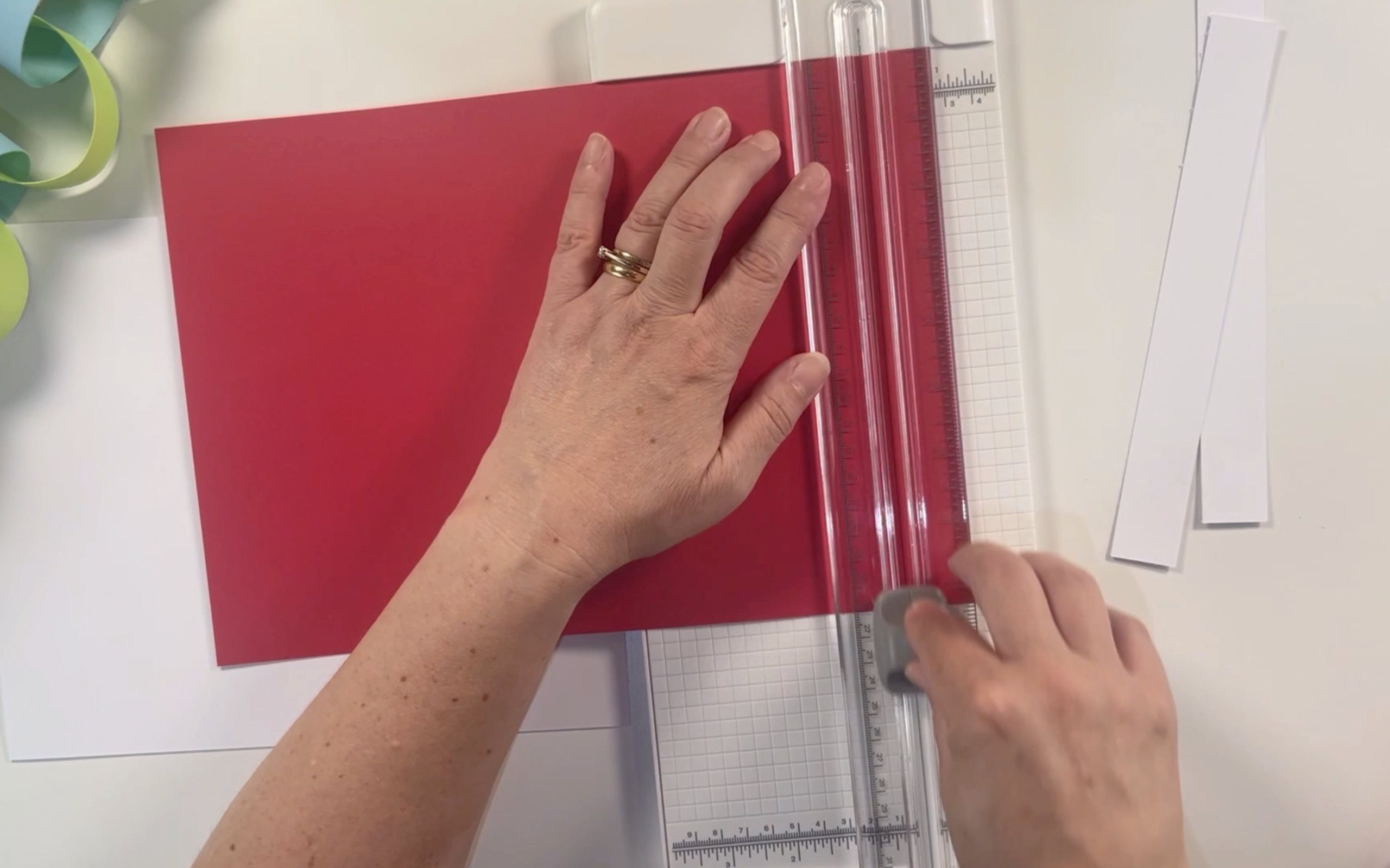 Cutting the red card along the shortest edge using the cricut paper trimmer.