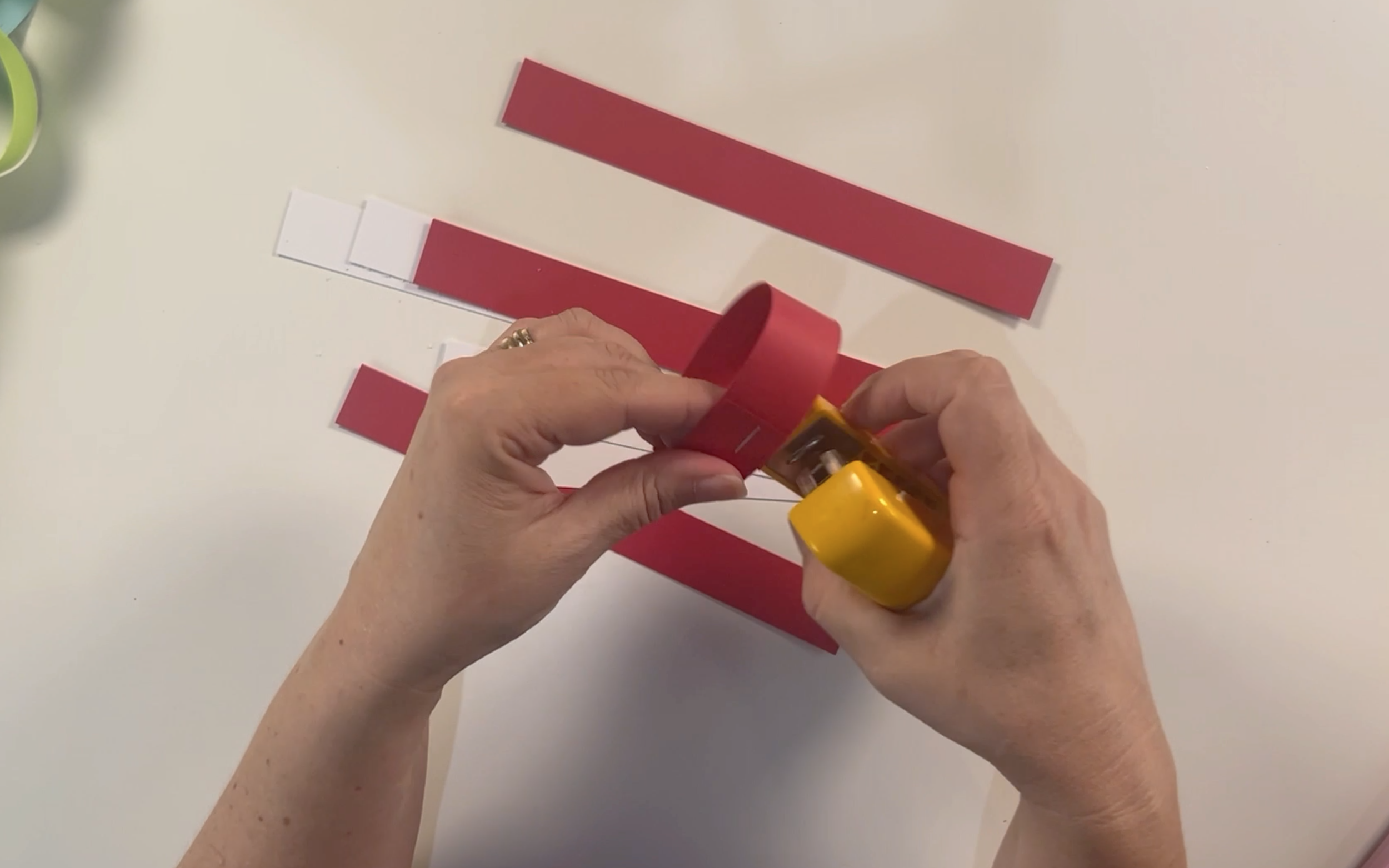 Using a stapler to secure the two pieces of card together