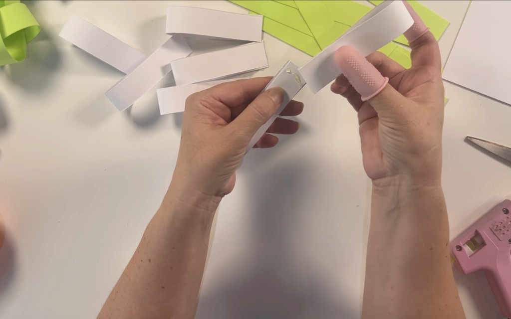 Taking 2 of the paper loops and glueing them together.
