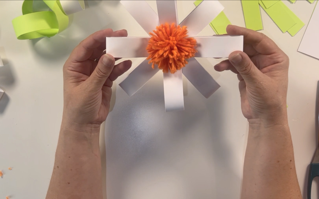 the completed card daisy with an orange pompom in the centre