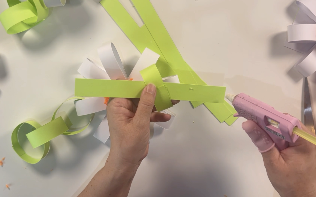 adding hot glue to the strips of card to make a loop