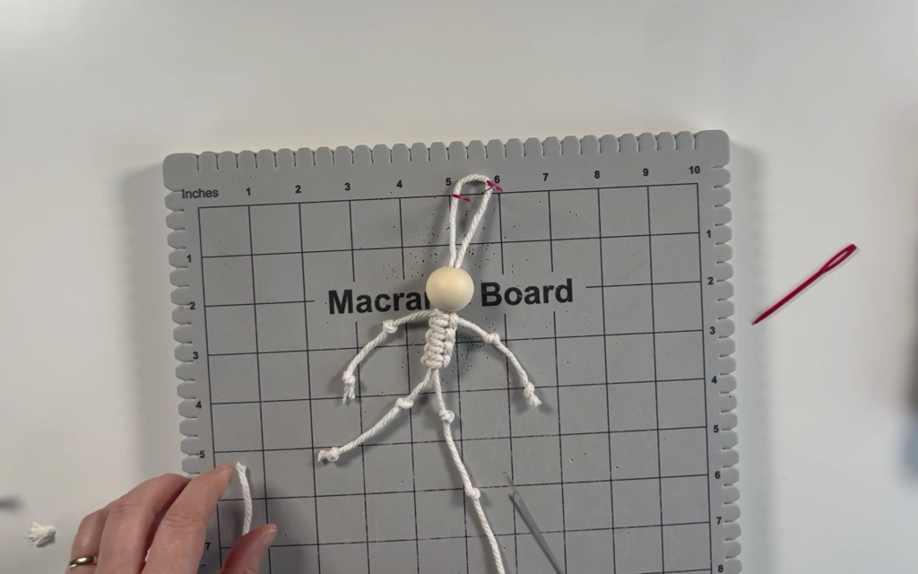2 knots tied in each of the strands of macrame cord to make the skeleton legs