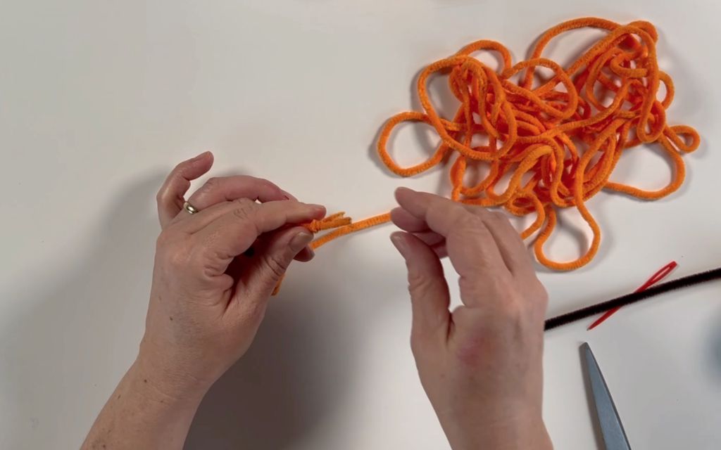 Two pieces of wool tied together to make a knot and the excess wool trimmed off 