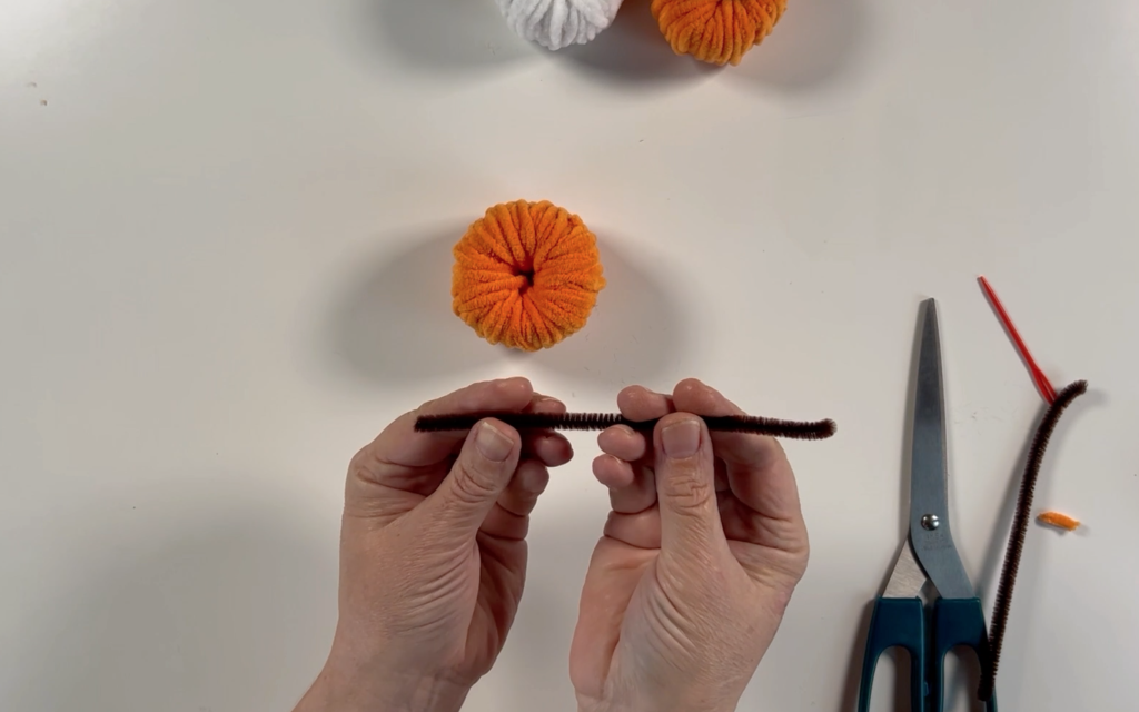 A brown chenille pipe cleaner that has been cut in half.