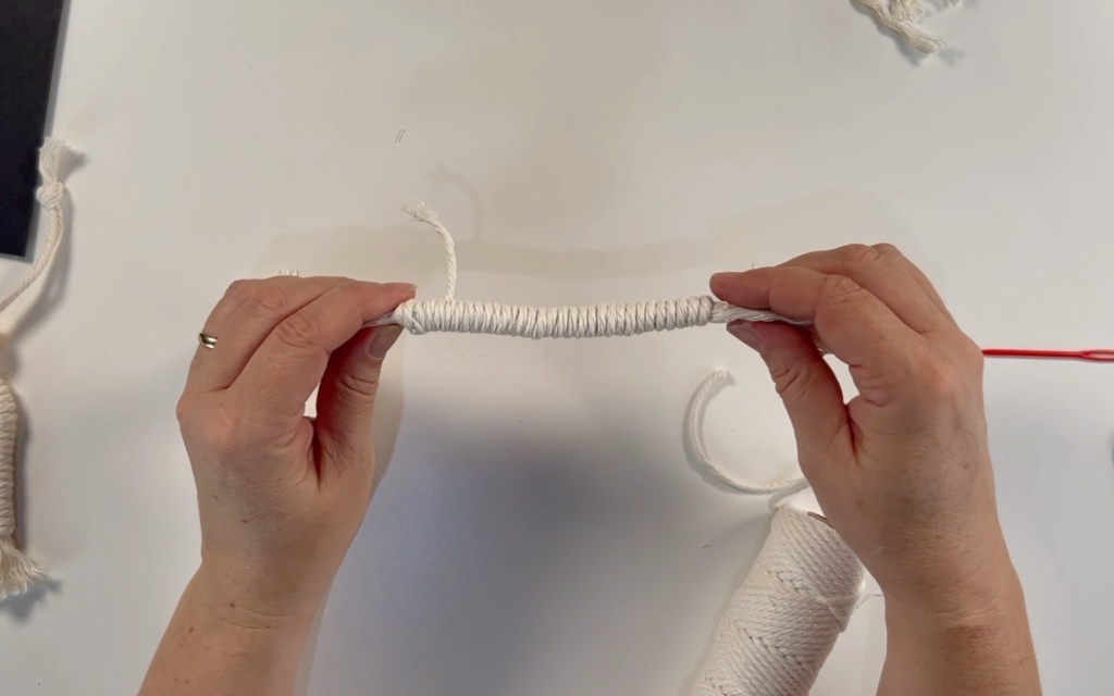 The finished length of wrapped cord with a strand of cord waiting to be cut off 