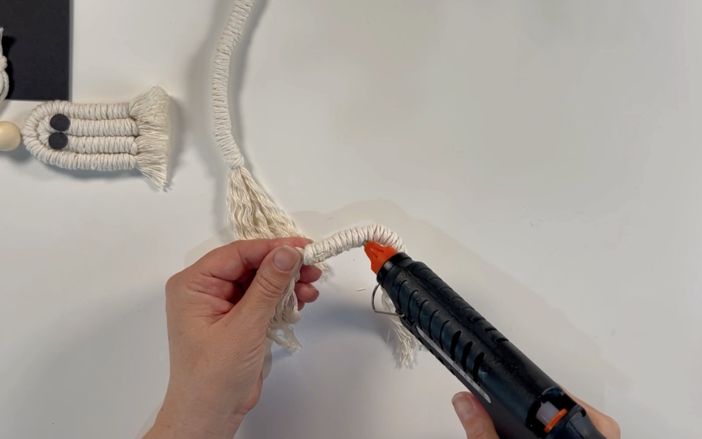 Adding hot glue to the inside of the wrapped cord