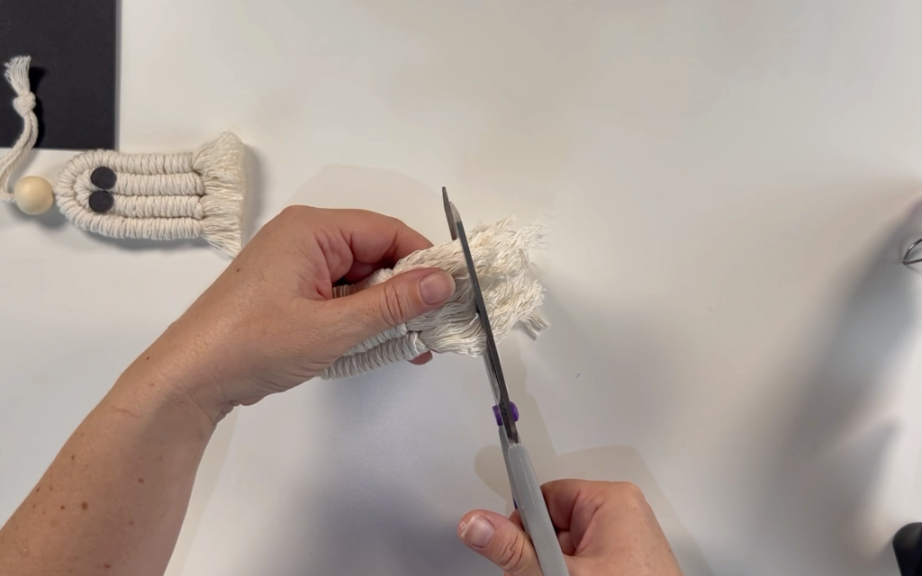 Trimming the cord at the bottom of the macrame ghost